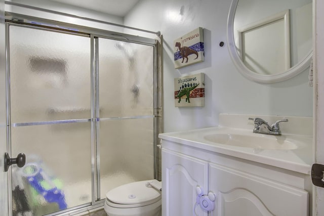 bathroom with toilet, a shower stall, and vanity