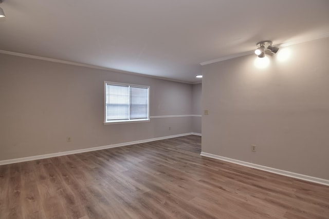 empty room featuring hardwood / wood-style floors and crown molding