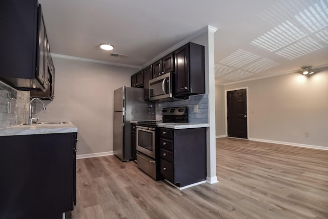 kitchen featuring backsplash, crown molding, sink, light wood-type flooring, and stainless steel appliances