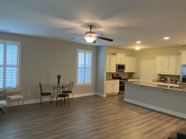 kitchen featuring white cabinets, stainless steel appliances, ceiling fan, and dark wood-type flooring