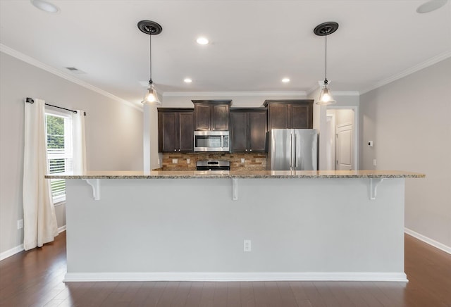 kitchen featuring pendant lighting, stainless steel appliances, dark hardwood / wood-style floors, and light stone countertops