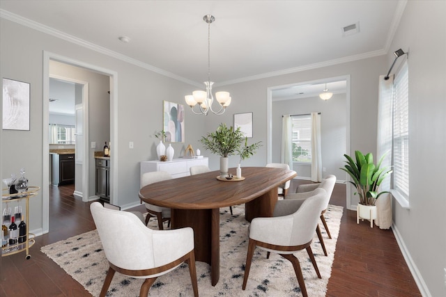 dining area featuring an inviting chandelier, crown molding, and dark hardwood / wood-style flooring