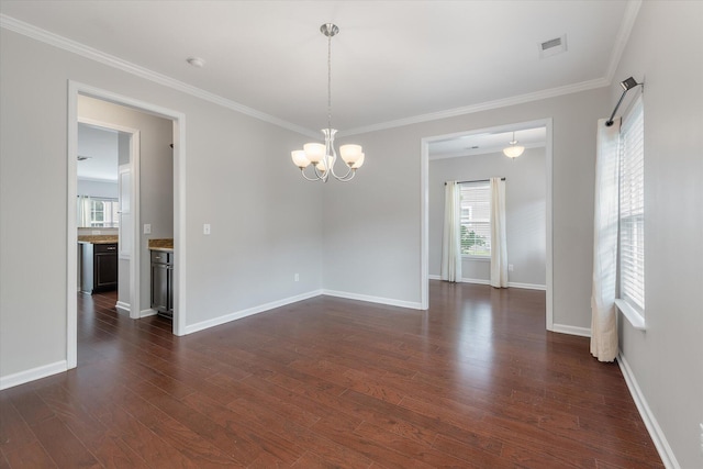 unfurnished room with crown molding, dark hardwood / wood-style flooring, and a chandelier