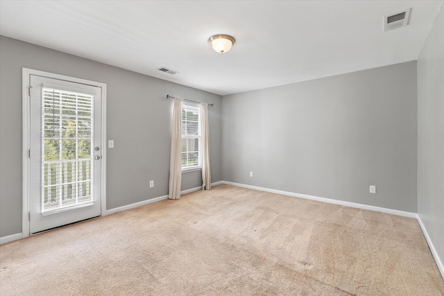 empty room with light carpet and a wealth of natural light