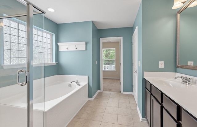 bathroom with tile patterned flooring, vanity, and plus walk in shower