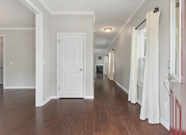 corridor with dark wood-type flooring and crown molding