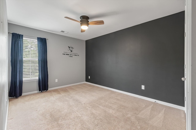 empty room featuring ceiling fan and light colored carpet