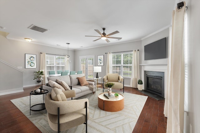 living room with ceiling fan, dark hardwood / wood-style floors, ornamental molding, and a wealth of natural light