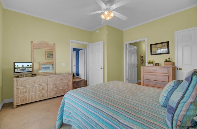 carpeted bedroom with ceiling fan and ornamental molding