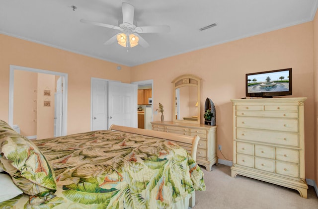 bedroom with ornamental molding, ensuite bath, light carpet, and ceiling fan