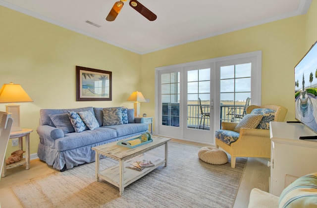 living room with ornamental molding, light hardwood / wood-style floors, and ceiling fan