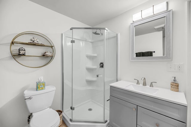bathroom with a stall shower, vanity, and toilet