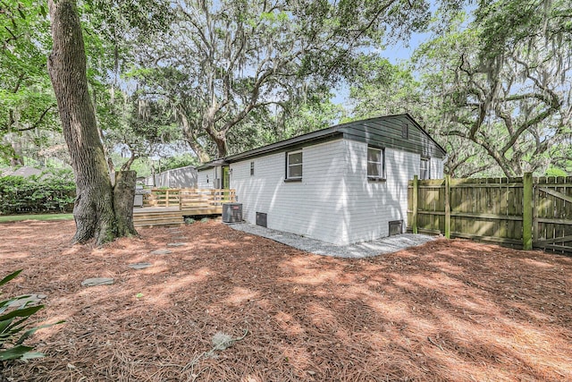 view of outbuilding with fence and central air condition unit