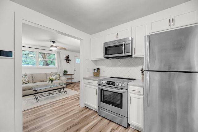 kitchen with stainless steel appliances, white cabinetry, light countertops, and tasteful backsplash