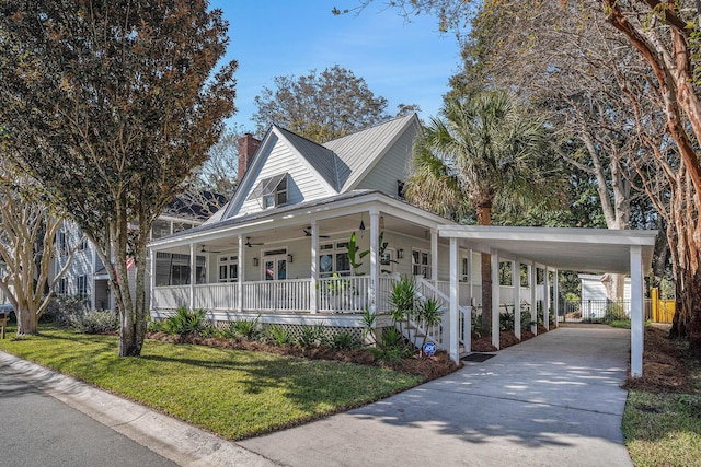 farmhouse inspired home featuring ceiling fan, a porch, a carport, and a front yard