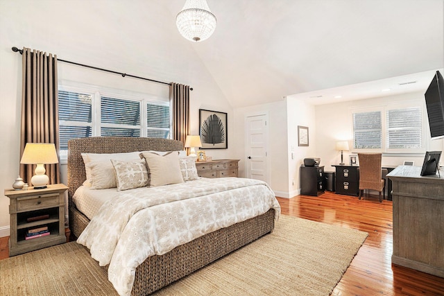 bedroom with lofted ceiling and wood-type flooring