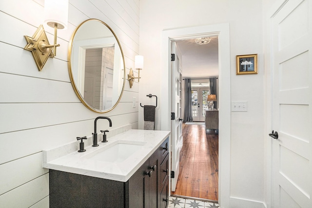 bathroom featuring vanity and wood walls