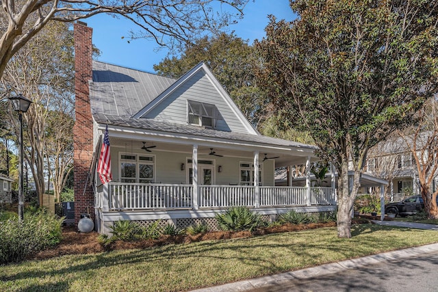 farmhouse inspired home featuring ceiling fan, a porch, and a front yard