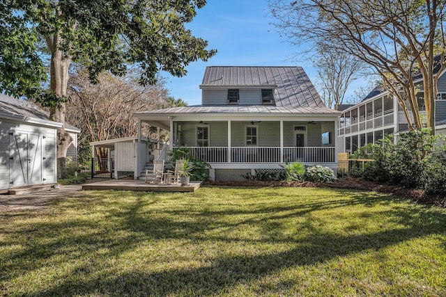 rear view of property with a storage shed, a yard, and covered porch