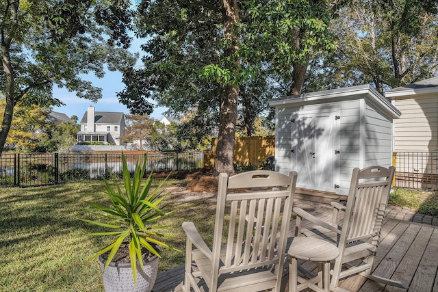 wooden deck with a storage shed and a lawn