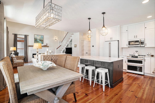 dining space with hardwood / wood-style floors and a chandelier