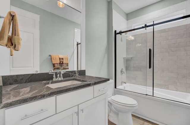 full bathroom with toilet, combined bath / shower with glass door, vanity, and wood-type flooring