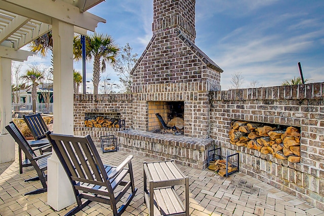 view of patio with an outdoor brick fireplace