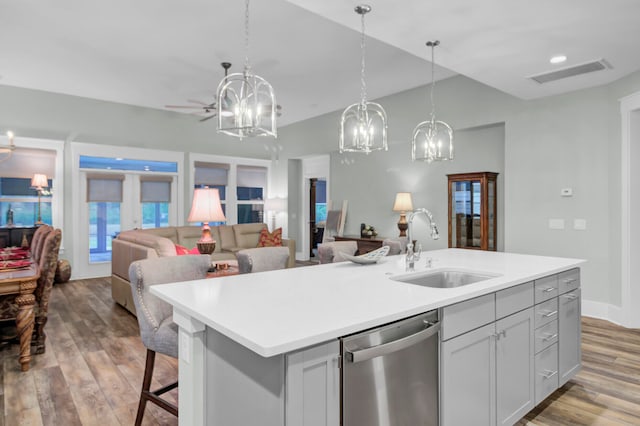 kitchen featuring french doors, light hardwood / wood-style floors, dishwasher, sink, and a kitchen island with sink