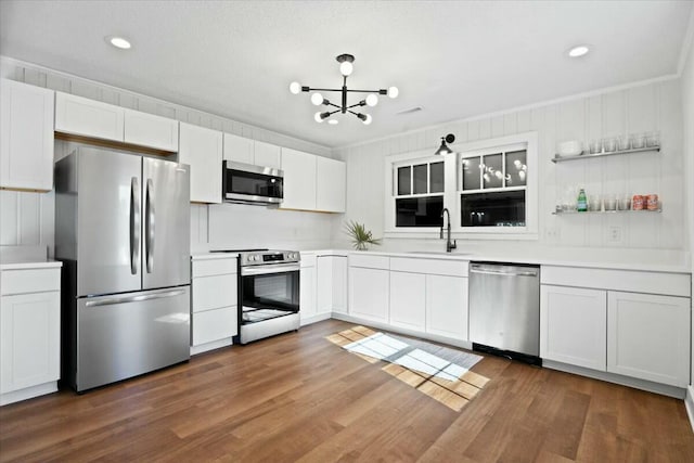 kitchen featuring a sink, a notable chandelier, appliances with stainless steel finishes, and dark wood-style flooring