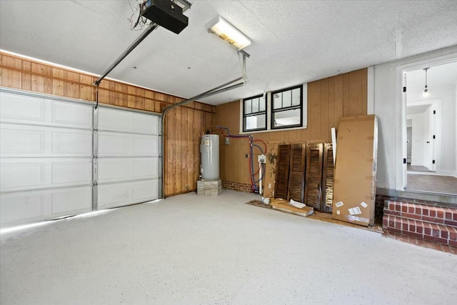 garage with water heater, wooden walls, and a garage door opener