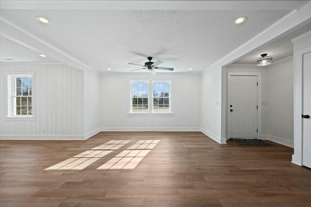 unfurnished room with a textured ceiling, wood finished floors, crown molding, baseboards, and ceiling fan