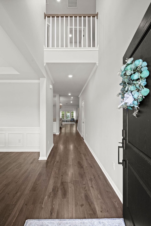 entrance foyer with dark hardwood / wood-style flooring and ornamental molding