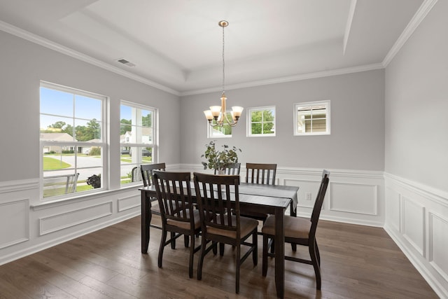 dining area with a tray ceiling, crown molding, dark wood-type flooring, and a notable chandelier