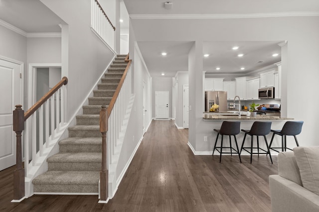 interior space featuring crown molding, hardwood / wood-style floors, and sink