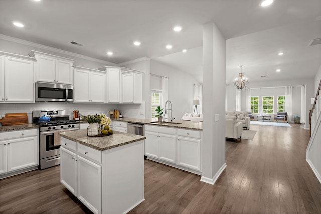 kitchen featuring stainless steel appliances, sink, stone countertops, white cabinets, and dark hardwood / wood-style floors