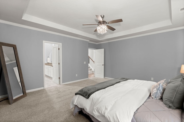 carpeted bedroom with ceiling fan, a raised ceiling, and connected bathroom