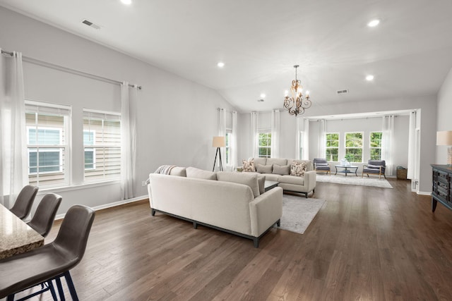 living room featuring dark hardwood / wood-style flooring, vaulted ceiling, and a notable chandelier