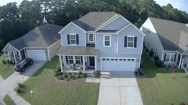 view of front facade featuring a front yard, a porch, and a garage