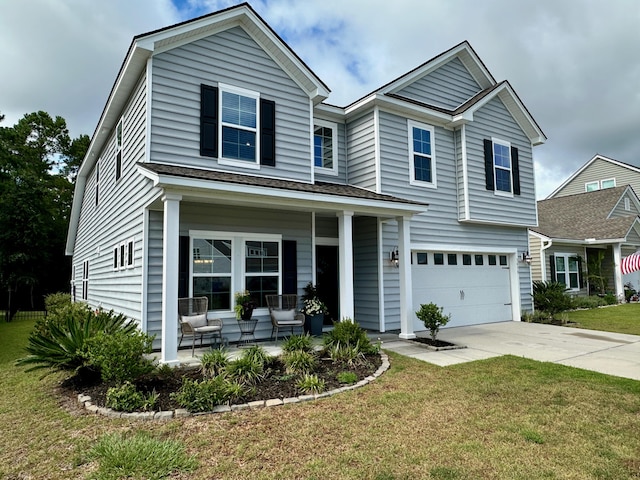 view of front of house with a front lawn, covered porch, and a garage