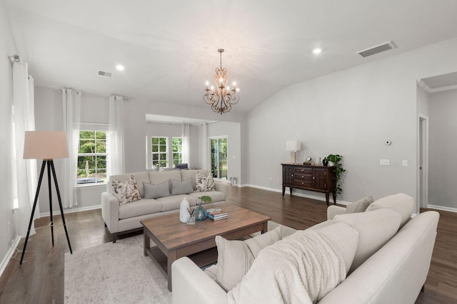 living room with dark hardwood / wood-style floors, lofted ceiling, and a notable chandelier