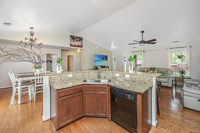 kitchen with a kitchen island with sink, ceiling fan with notable chandelier, sink, black dishwasher, and light hardwood / wood-style floors