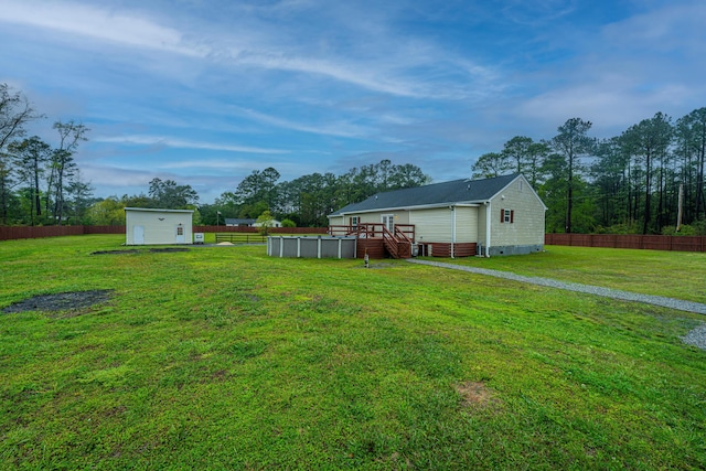 view of yard featuring a pool side deck and a storage unit