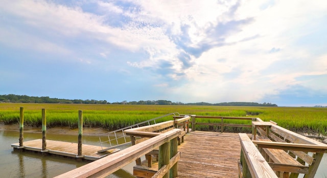 view of dock with a rural view and a water view