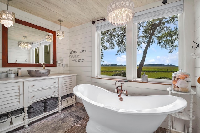 bathroom featuring a washtub, a rural view, a chandelier, wooden walls, and wood ceiling