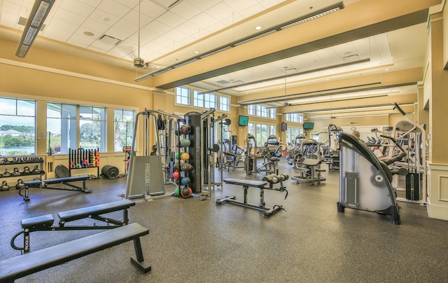 exercise room featuring a towering ceiling