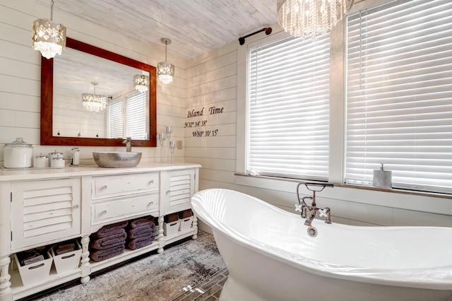 bathroom featuring wood walls, a chandelier, a bathtub, vanity, and wood ceiling