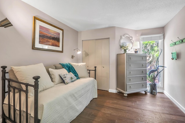 bedroom featuring a textured ceiling, dark hardwood / wood-style floors, and a closet