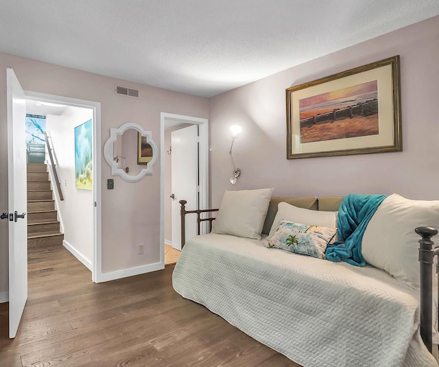 bedroom featuring wood-type flooring and a textured ceiling