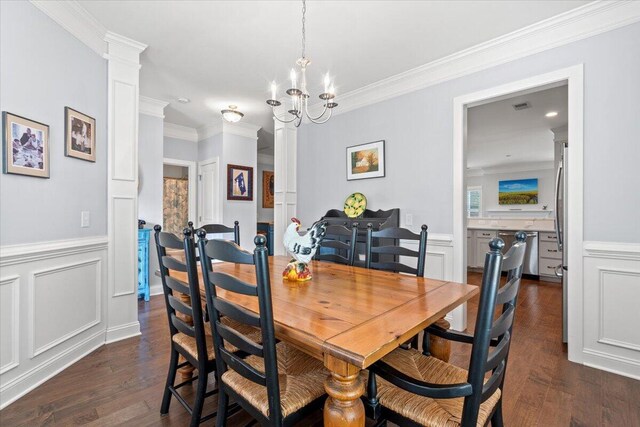 3751 Copahee Sound Dr, Mount Pleasant, SC 29466 - dining room featuring ornate columns, dark wood finished floors, ornamental molding, a wainscoted wall, and a chandelier