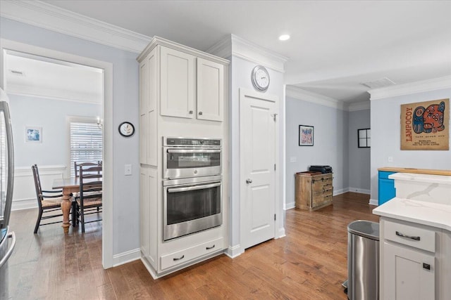 3751 Copahee Sound Dr, Mount Pleasant, SC 29466 - kitchen featuring crown molding, stainless steel appliances, wood finished floors, white cabinets, and light stone counters